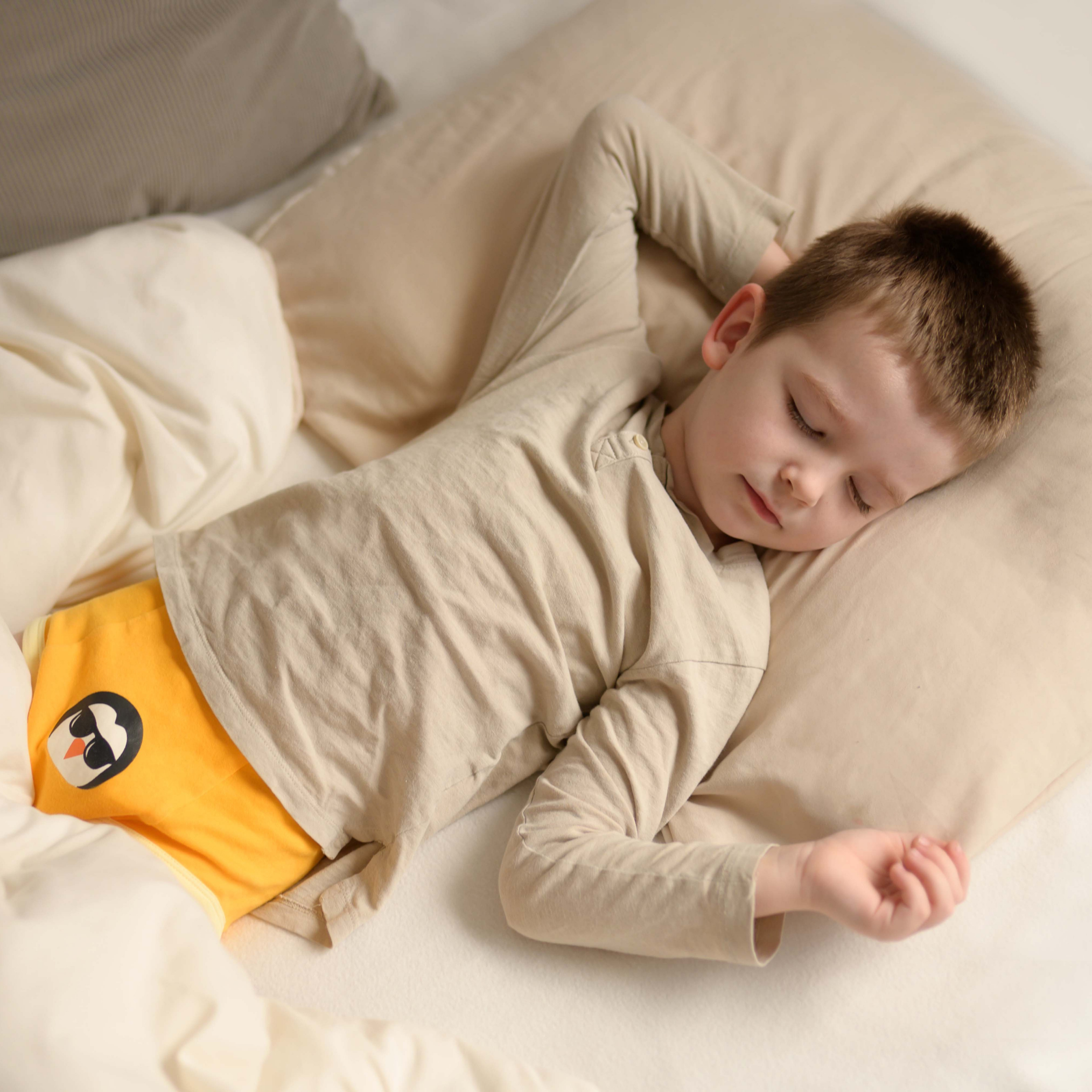 A child sleeping peacfully wearing MyBeeBear overnight pants 