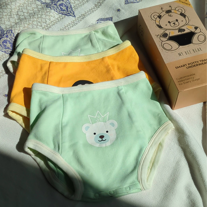 Bedwetting underwear for girls and boys laying on a sheet 