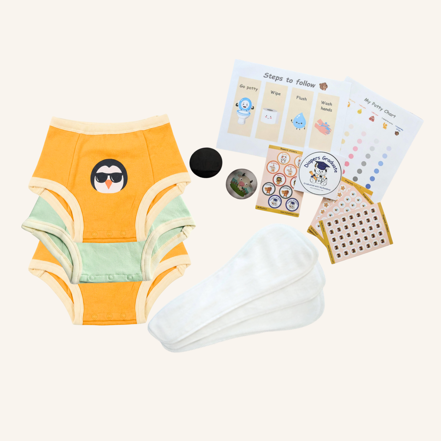 Baby training pants with a penguin design, a white diaper, and educational cards on a white background.