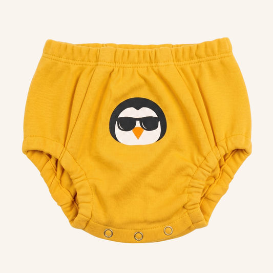 Yellow baby bloomers with a penguin design on a white background