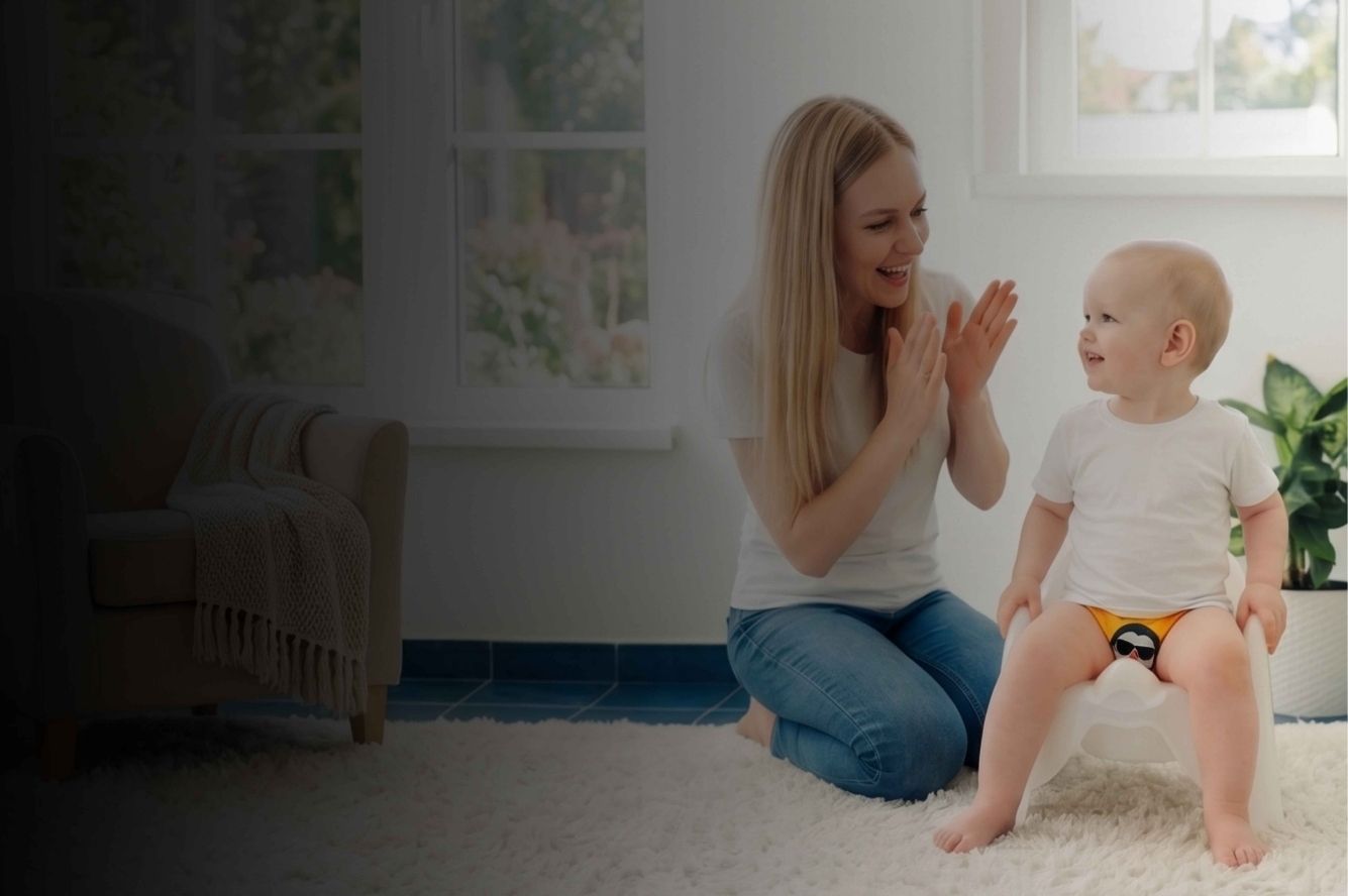 Mom and toddler in the middle of the room. Toddler sitting on the potty wearing yellow training underwear 